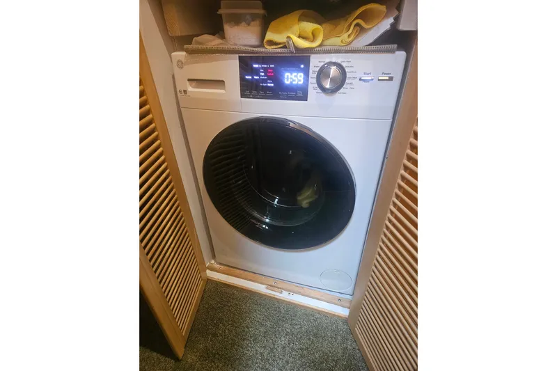 Slide: The Image of Front-loading washing machine in a wooden cabinet, displaying a digital timer. - 25