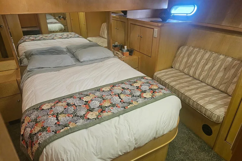 Slide: The Image of Cozy bedroom in a 1995 Symbol 55 yacht with floral bedspread and striped seating. - 26