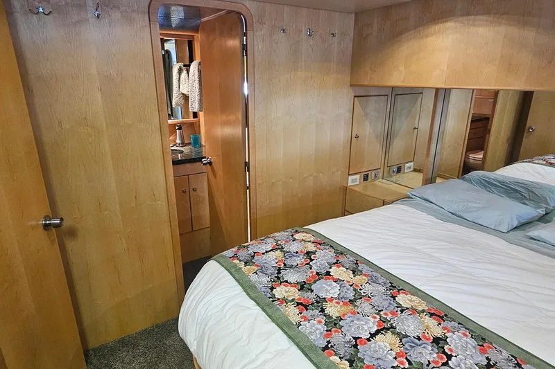 Slide: The Image of Cozy bedroom with floral bedspread, wooden walls, and open door to bathroom in Symbol 55 yacht. - 28