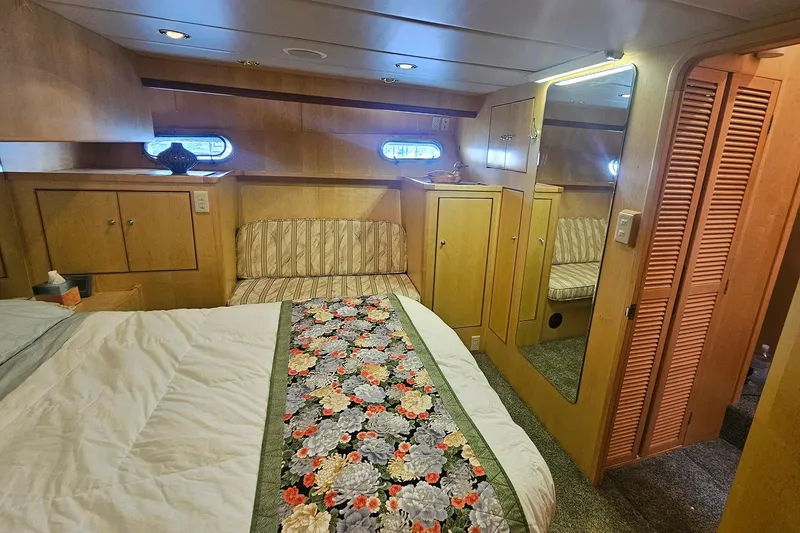 Slide: The Image of Luxurious 1995 Symbol 55 yacht bedroom with floral bedspread, wood paneling, and mirrored closet. - 31
