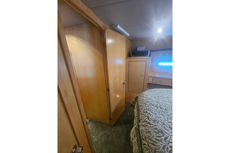 Slide: The Image of Interior of a 1995 Symbol 55 yacht bedroom with wooden cabinetry and patterned bedding. - 33
