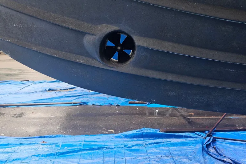 Slide: The Image of Close-up of a 1995 Symbol 55 boat hull with a bow thruster, on a blue tarp. - 5