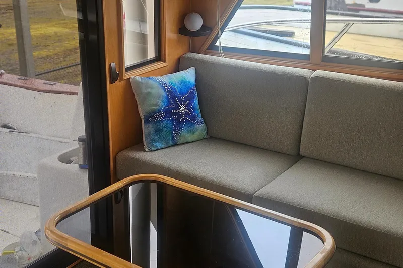 Slide: The Image of Cozy boat interior with gray sofa, starfish pillow, and wooden table, Symbol 55, 1995. - 8