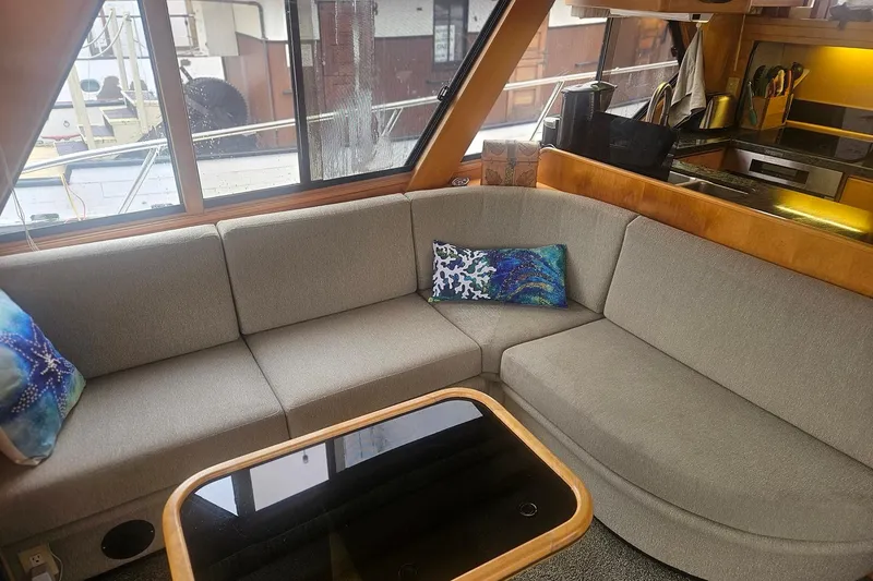 Slide: The Image of Cozy yacht interior with gray sectional sofa, colorful pillows, and wooden accents, Symbol 55, 1995. - 9