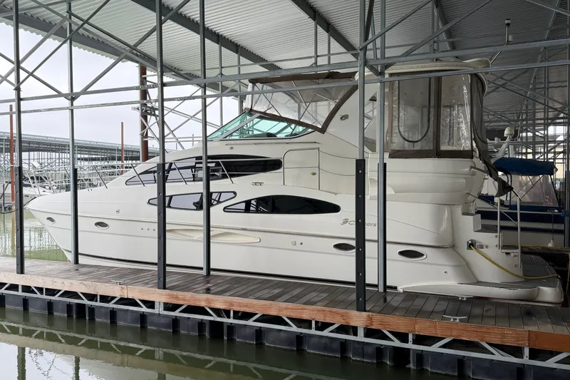 The Image of 2003 Cruisers Yachts 405 Express Motoryacht docked in a covered marina. - 1