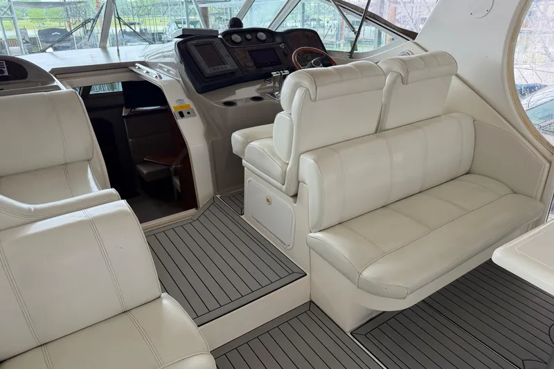 Slide: The Image of 2003 Cruisers Yachts 405 Express Motoryacht interior with white leather seating and helm controls. - 11