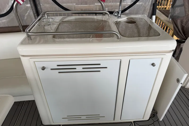 Slide: The Image of 2003 Cruisers Yachts 405 Express Motoryacht kitchenette with sink and storage cabinets. - 22