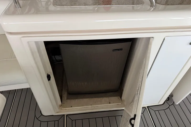 Slide: The Image of Open cabinet with mini fridge on 2003 Cruisers Yachts 405 Express Motoryacht. - 23