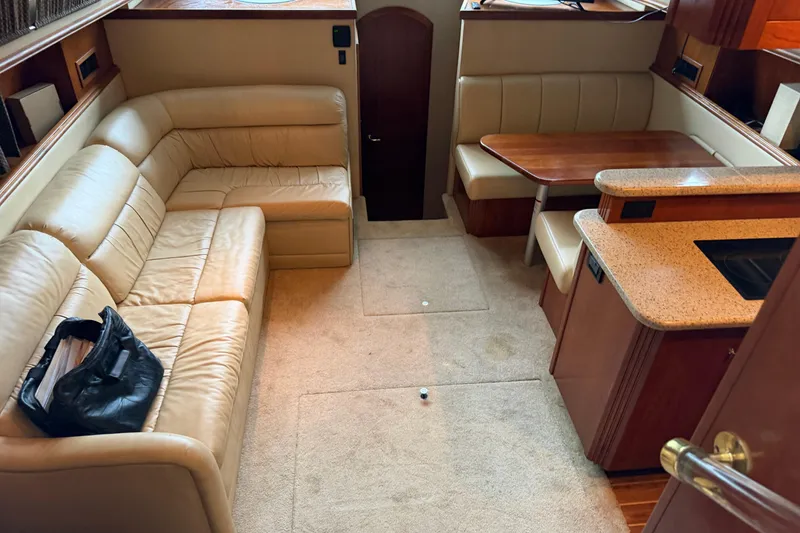 Slide: The Image of 2003 Cruisers Yachts 405 Express Motoryacht interior with beige leather seating and wooden dining area. - 28