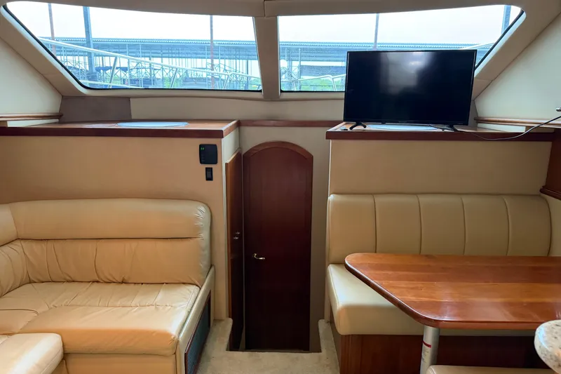 Slide: The Image of Interior of 2003 Cruisers Yachts 405 Express Motoryacht with beige seating and TV. - 32
