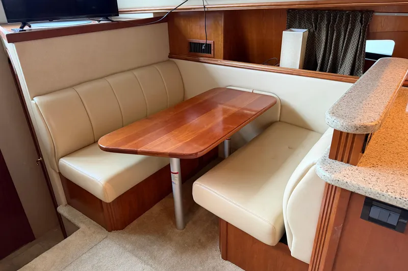 Slide: The Image of 2003 Cruisers Yachts 405 Express Motoryacht interior with cozy dining area and wooden table. - 33