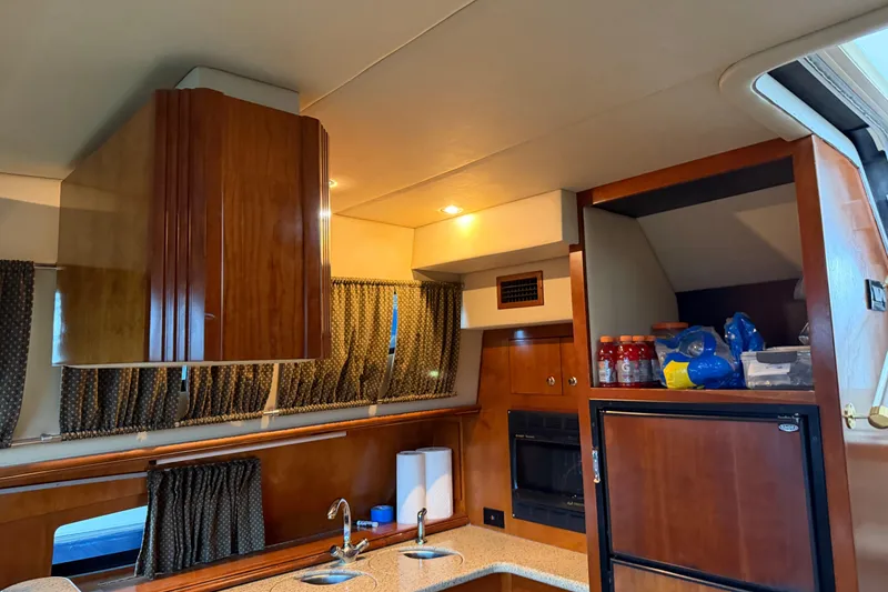 Slide: The Image of Interior of 2003 Cruisers Yachts 405 Express Motoryacht kitchen with wood cabinetry and appliances. - 35
