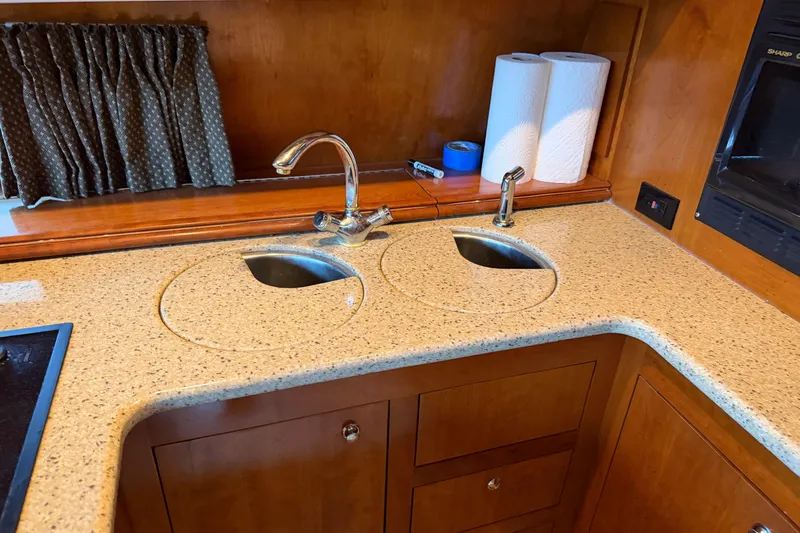 Slide: The Image of Kitchen area of 2003 Cruisers Yachts 405 Express Motoryacht with dual sinks and wooden cabinetry. - 37