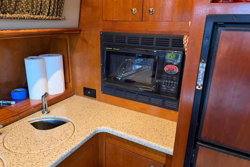Slide: The Image of 2003 Cruisers Yachts 405 Express Motoryacht kitchen with microwave, sink, and paper towels. - 38