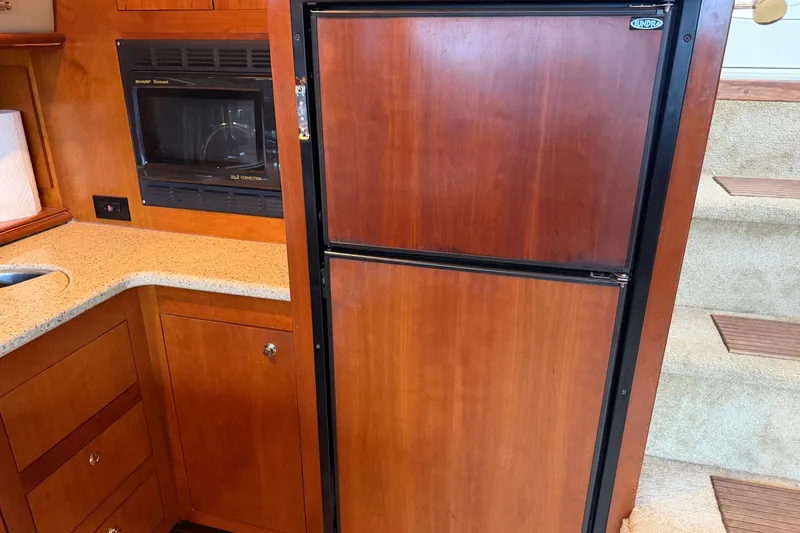 Slide: The Image of 2003 Cruisers Yachts 405 Express Motoryacht kitchen with wood cabinetry and appliances. - 39