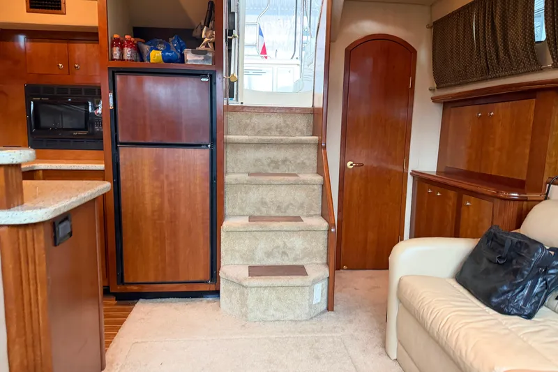 Slide: The Image of Interior of 2003 Cruisers Yachts 405 Express Motoryacht with stairs, cabinets, and seating area. - 49
