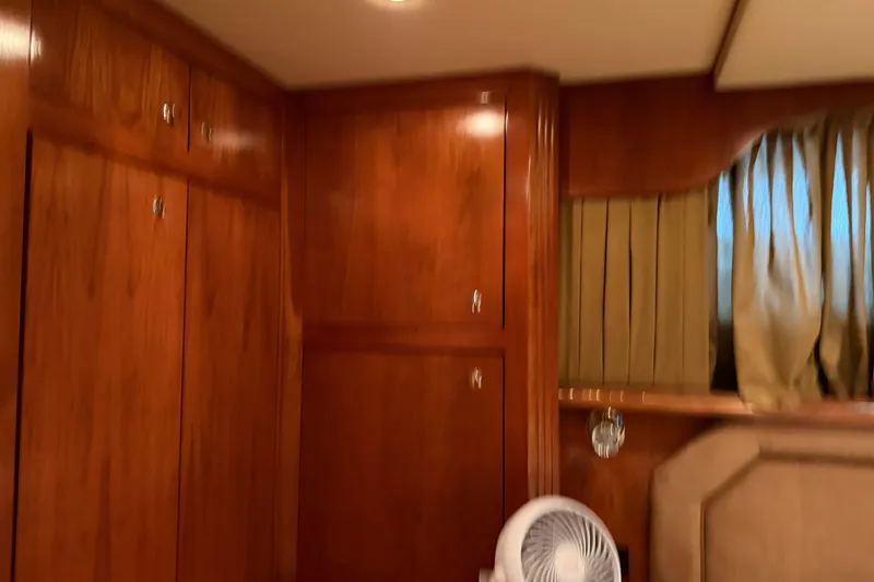 Slide: The Image of Interior of 2003 Cruisers Yachts 405 Express Motoryacht with wooden cabinetry and curtains. - 56