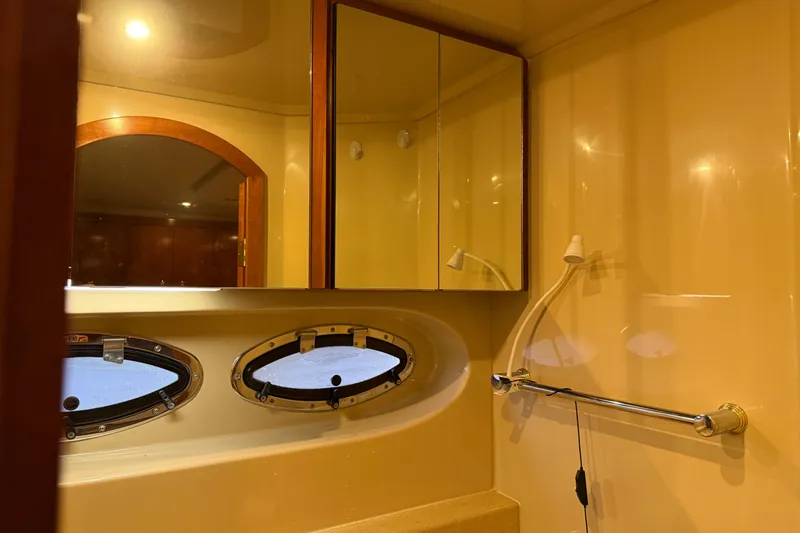 Slide: The Image of Bathroom interior of 2003 Cruisers Yachts 405 Express Motoryacht with oval windows and mirrored cabinet. - 60