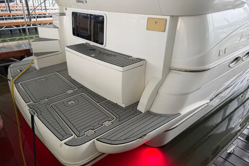 Slide: The Image of 2003 Cruisers Yachts 405 Express Motoryacht with sleek deck design and red underwater lights. - 7