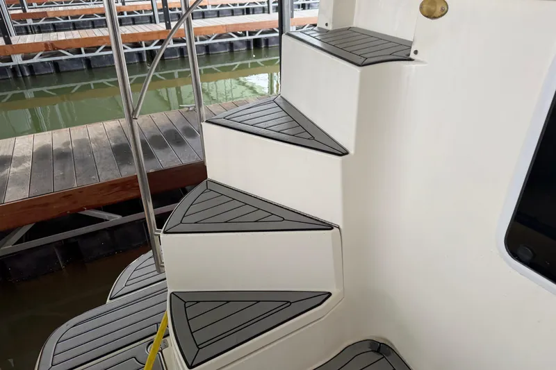 Slide: The Image of Staircase on 2003 Cruisers Yachts 405 Express Motoryacht, docked near wooden pier. - 9