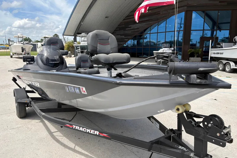 Slide: The Image of 2022 Tracker Pro Team 175 boat on trailer, parked outside a modern building. - 10