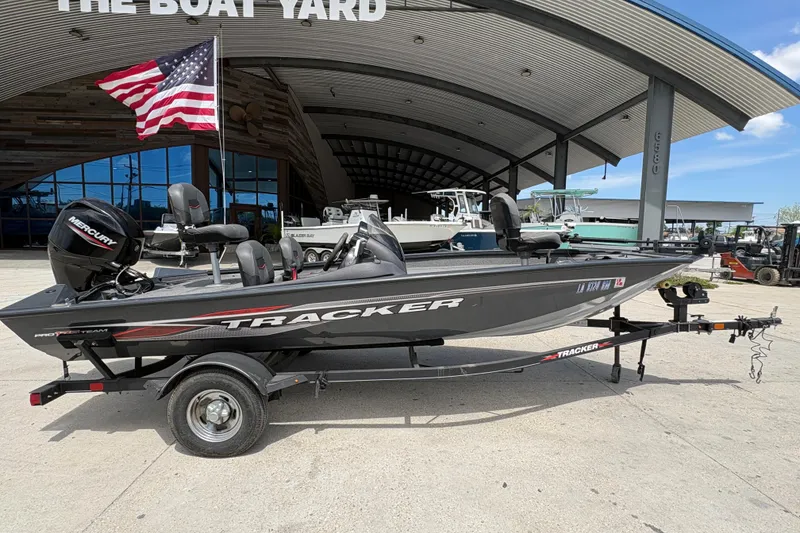 Slide: The Image of 2022 Tracker Pro Team 175 boat on trailer at dealership with American flag. - 3