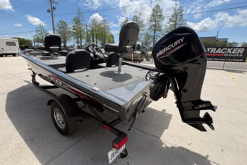 Slide: The Image of 2022 Tracker Pro Team 175 boat with Mercury engine, parked outdoors under a clear sky. - 6
