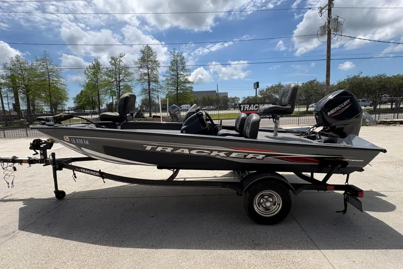 Slide: The Image of 2022 Tracker Pro Team 175 boat on trailer under a partly cloudy sky. - 7