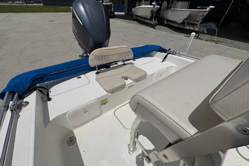 Slide: The Image of 2008 Hydra-Sports Bay Bolt 23 boat interior with seating and motor, docked outdoors. - 11