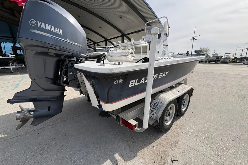 Slide: The Image of Blazer Bay 2020 boat with Yamaha engine on a trailer, parked outdoors. - 4
