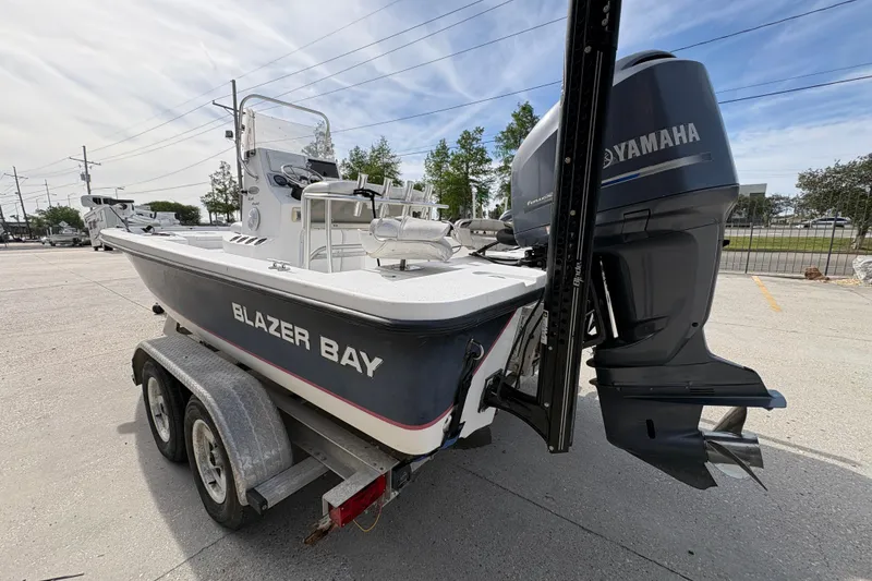 Slide: The Image of Blazer Bay 2020 boat on trailer with Yamaha outboard motor, parked outdoors. - 6