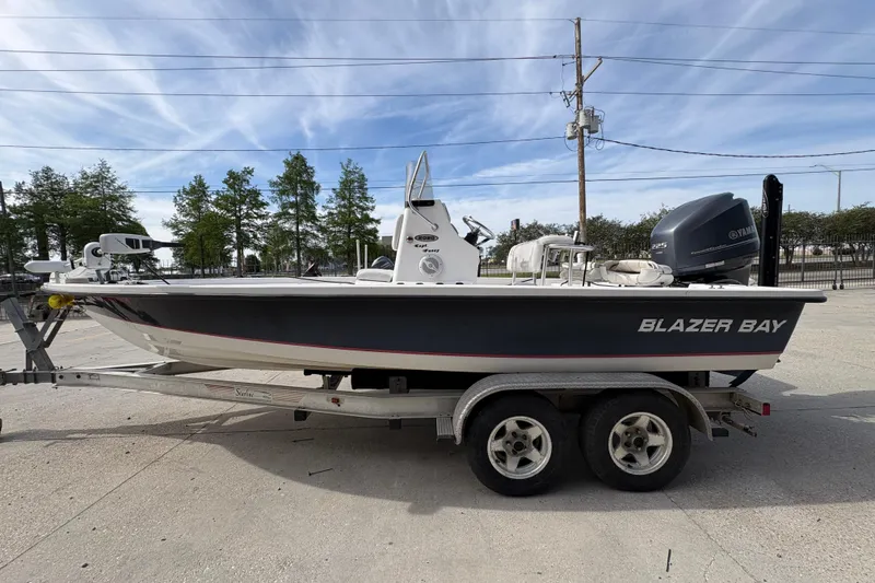 Slide: The Image of 2010 Blazer Bay 2020 boat on trailer with Yamaha engine, parked outdoors. - 7