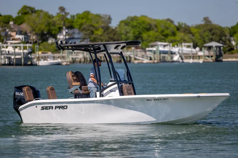 The Image of 2025 Sea Pro 202 Center Console boat on water, with lush green shoreline background. - 1