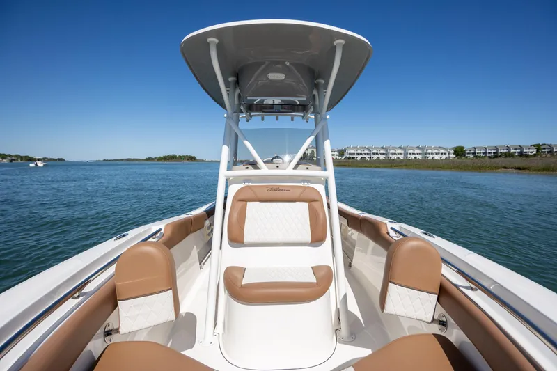 Slide: The Image of 2022 Pioneer 202 Islander boat interior with tan seating on a sunny day. - 10