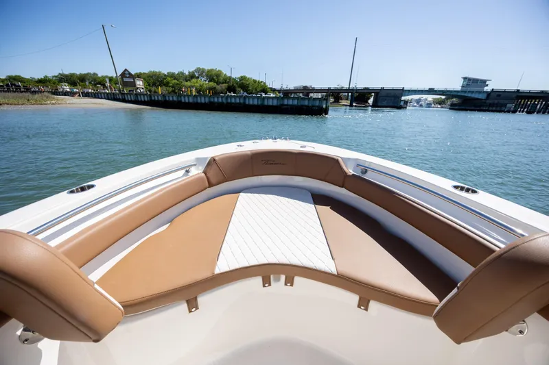 Slide: The Image of 2022 Pioneer 202 Islander boat interior with tan seating, overlooking a scenic waterway. - 11