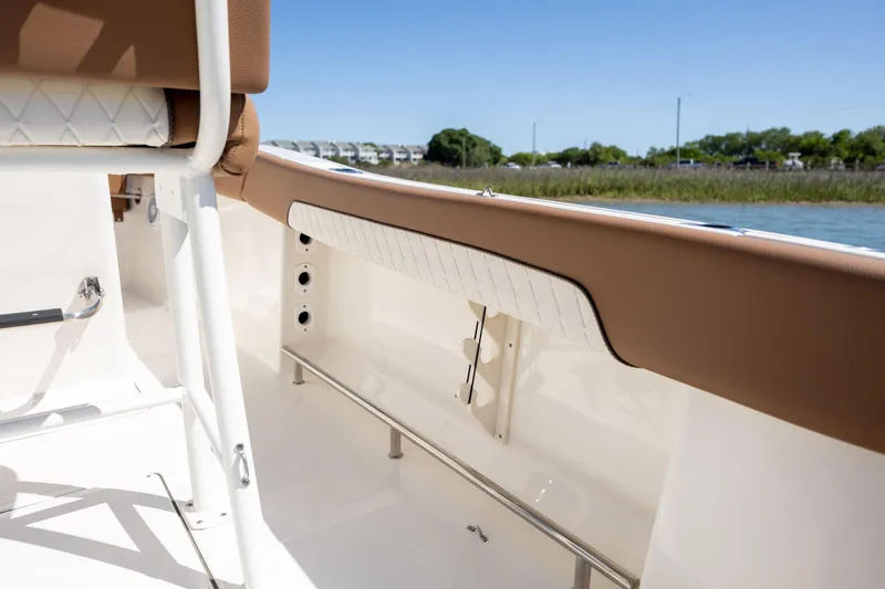 Slide: The Image of 2022 Pioneer 202 Islander boat interior with tan and white seating, near water. - 14