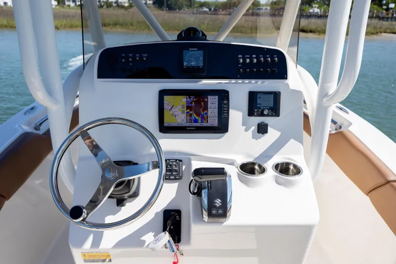 Slide: The Image of 2022 Pioneer 202 Islander boat dashboard with steering wheel and navigation controls. - 19
