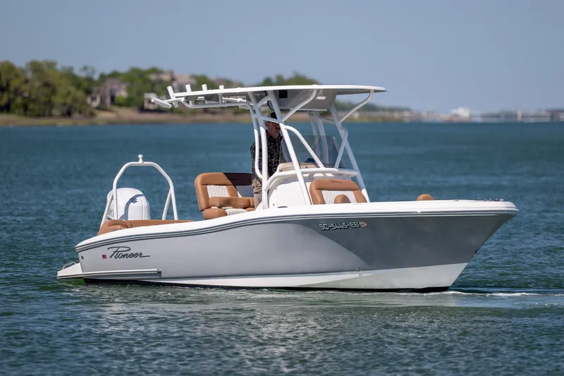 Slide: The Image of 2022 Pioneer 202 Islander boat cruising on a calm lake with scenic background. - 4