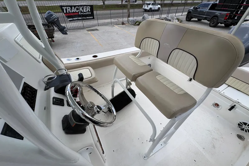 Slide: The Image of 2015 Sea Fox 249 Avenger boat interior with steering wheel and beige seating. - 13