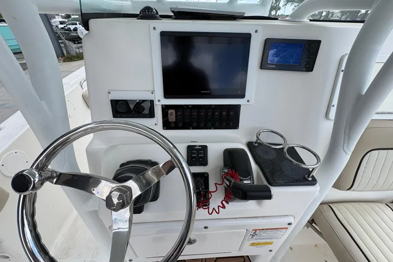 Slide: The Image of 2015 Sea Fox 249 Avenger boat dashboard with steering wheel, Garmin display, and controls. - 15