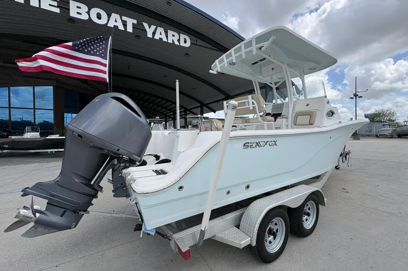 Slide: The Image of 2015 Sea Fox 249 Avenger boat on trailer, displayed at The Boat Yard with American flag. - 3