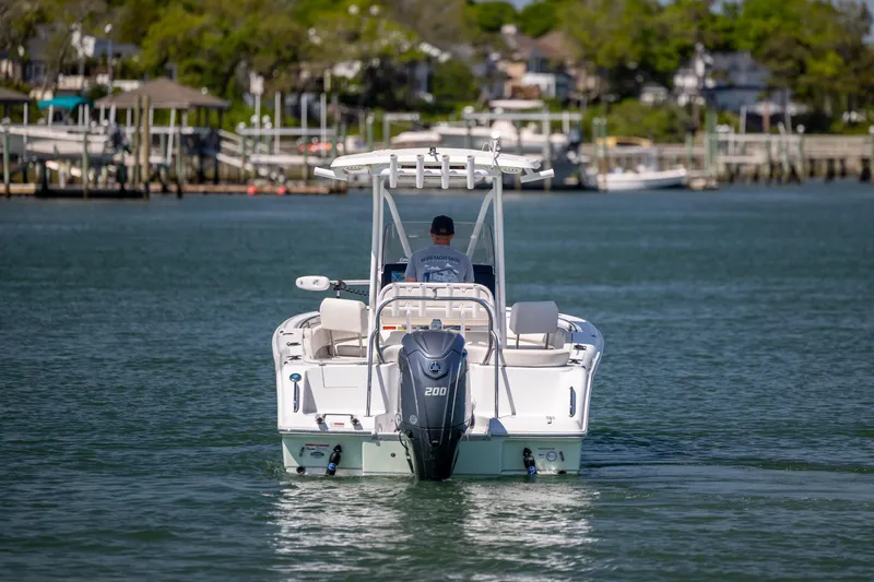 Slide: The Image of 2024 Sea Hunt Ultra 234 boat cruising on a calm waterway. - 10