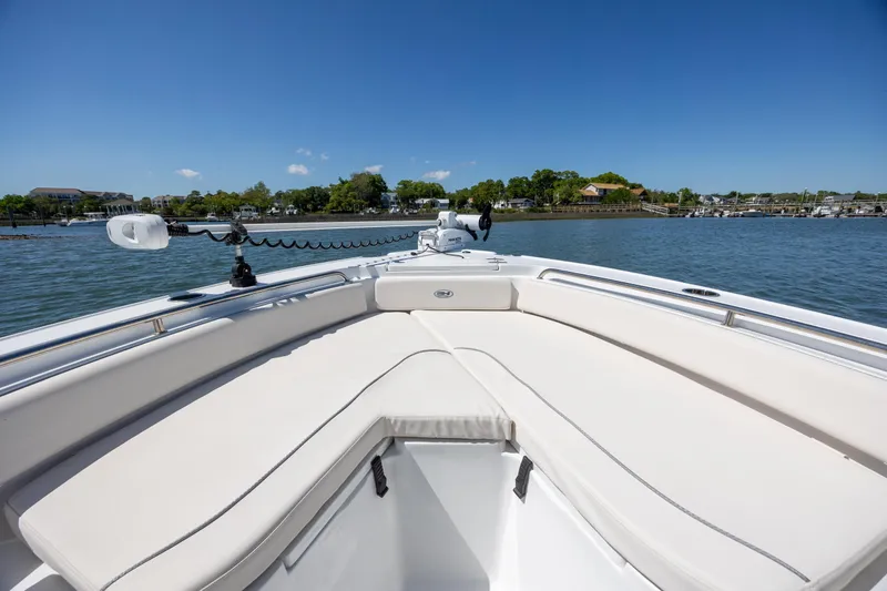 Slide: The Image of 2024 Sea Hunt Ultra 234 boat with spacious seating on calm water. - 11
