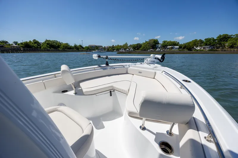 Slide: The Image of 2024 Sea Hunt Ultra 234 boat with spacious seating on calm water. - 12