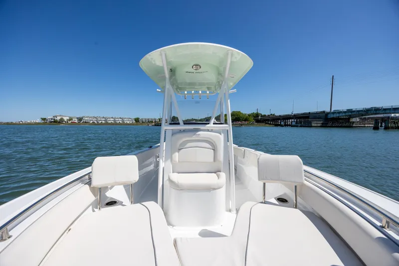 Slide: The Image of 2024 Sea Hunt Ultra 234 boat on calm water, featuring sleek white seating and a canopy. - 13