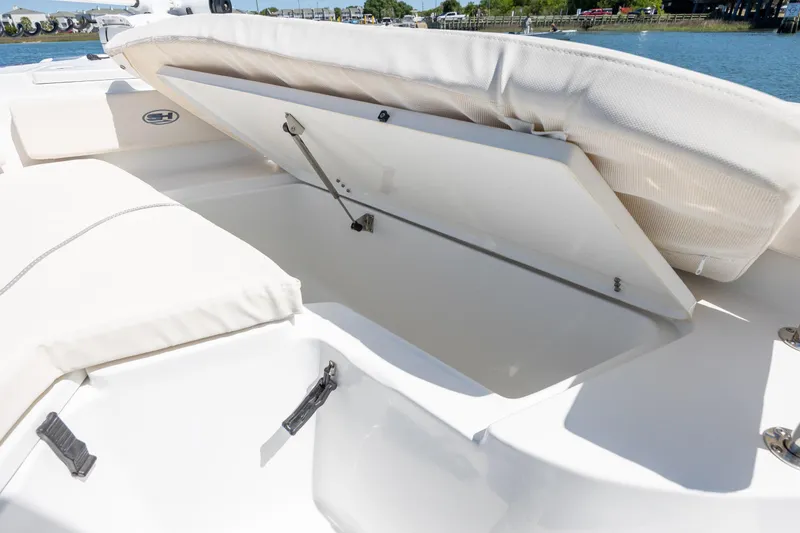 Slide: The Image of 2024 Sea Hunt Ultra 234 boat storage compartment open on deck. - 17