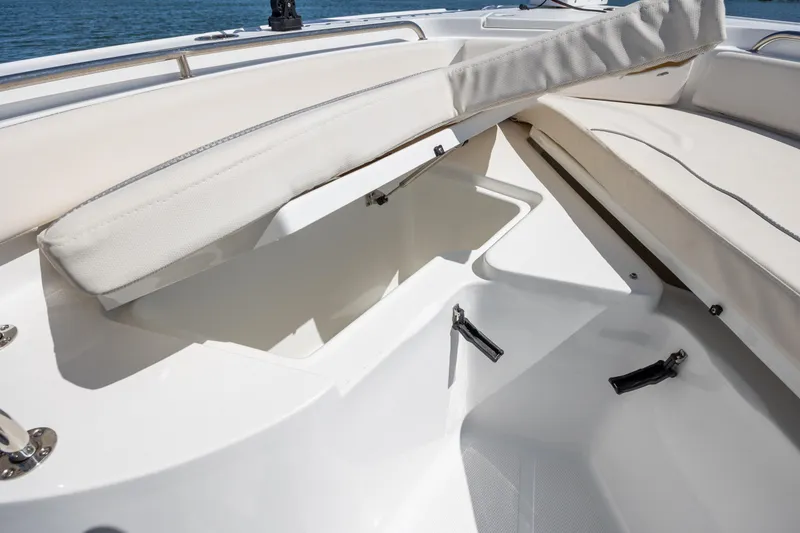 Slide: The Image of 2024 Sea Hunt Ultra 234 boat with open storage compartment and cushioned seating. - 18