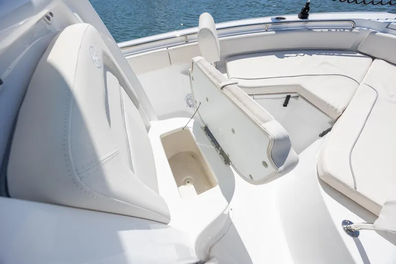 Slide: The Image of 2024 Sea Hunt Ultra 234 boat interior with white cushioned seating and storage compartment. - 19