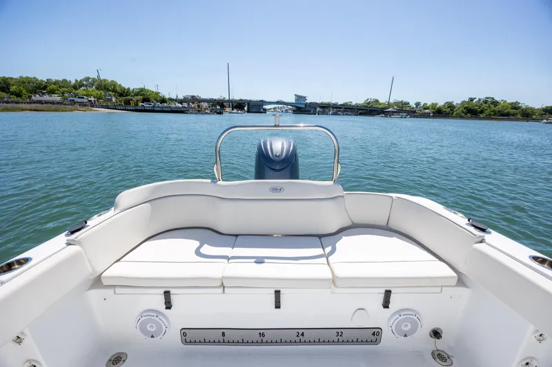 Slide: The Image of 2024 Sea Hunt Ultra 234 boat with spacious seating, cruising on a serene waterway. - 21