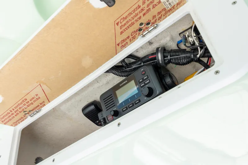 Slide: The Image of 2024 Sea Hunt Ultra 234 boat compartment with Garmin marine radio and wiring. - 30